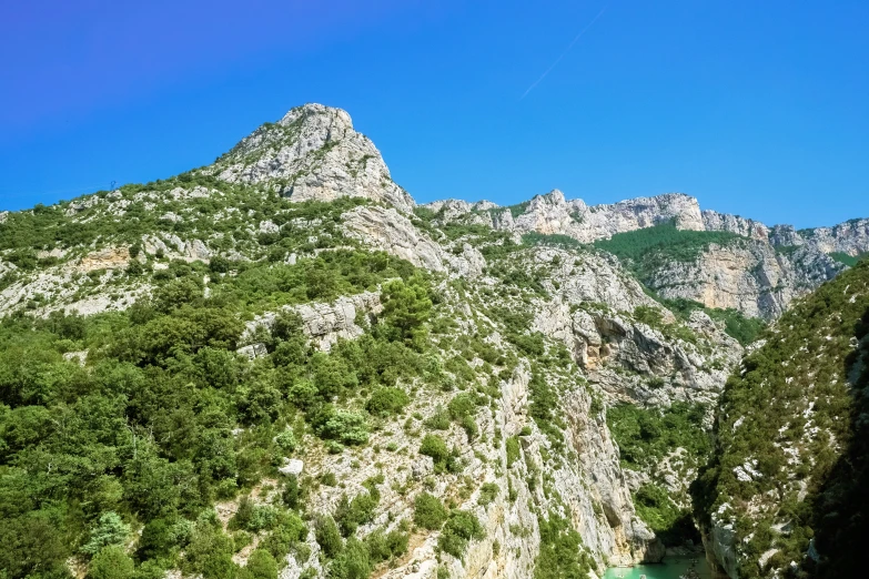 there is some cliffs and mountains that are on the other side of a river