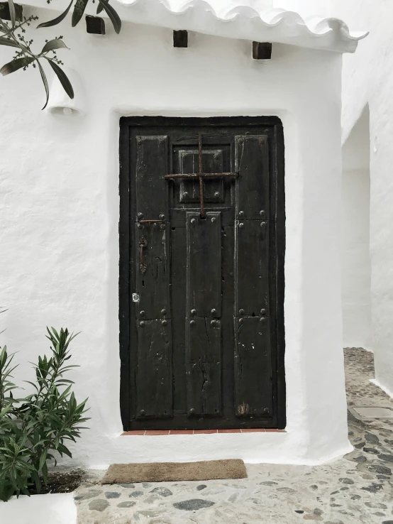 a very old wooden door on a white building