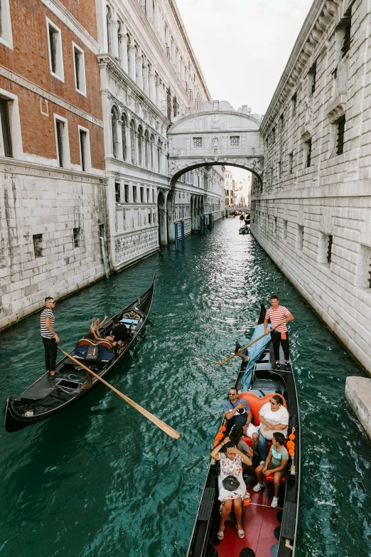 people are riding down the canals on small boats