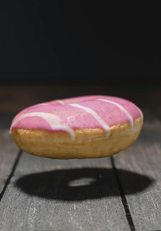 a small donut sitting on top of wooden surface