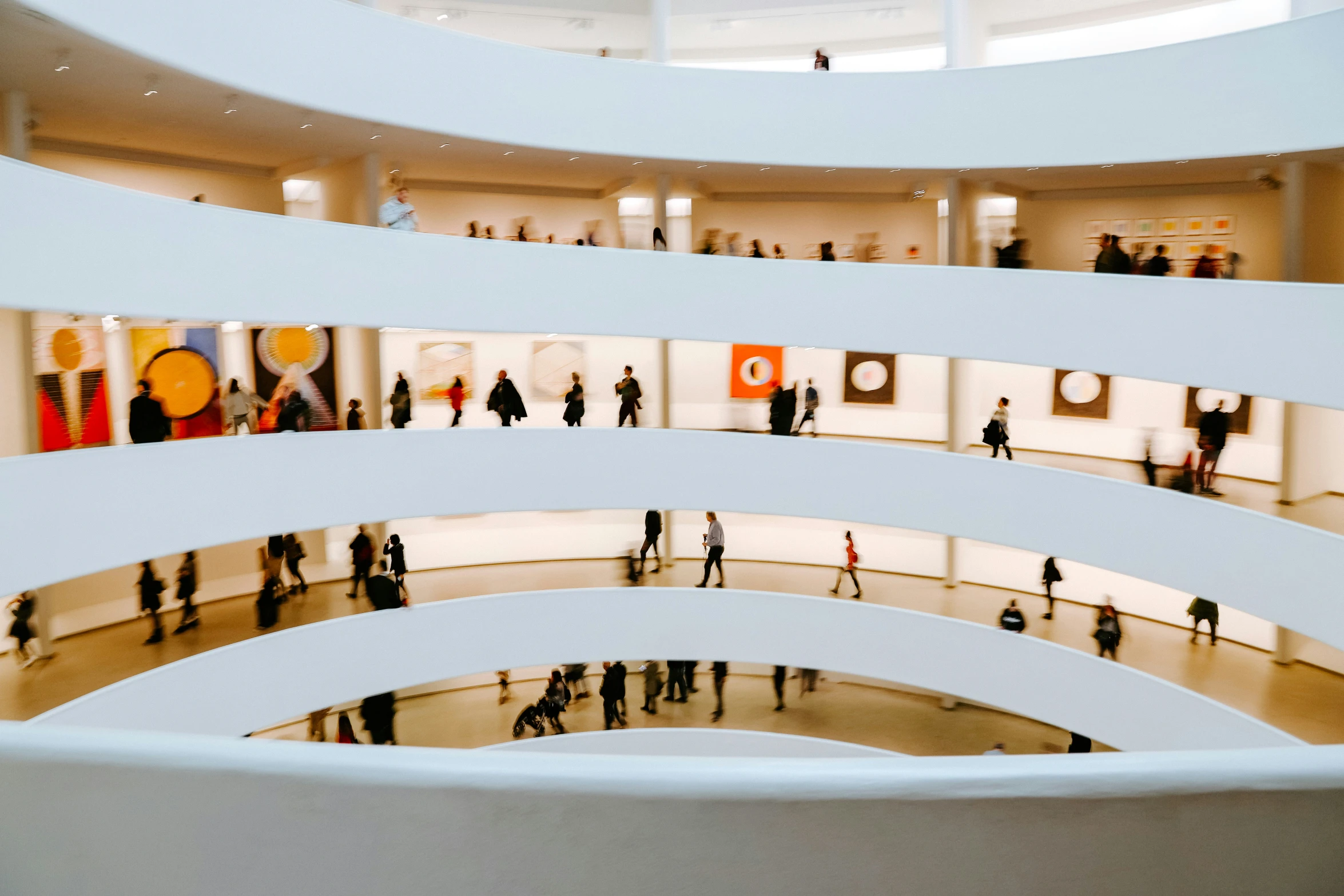 people are walking around an art museum with white walls