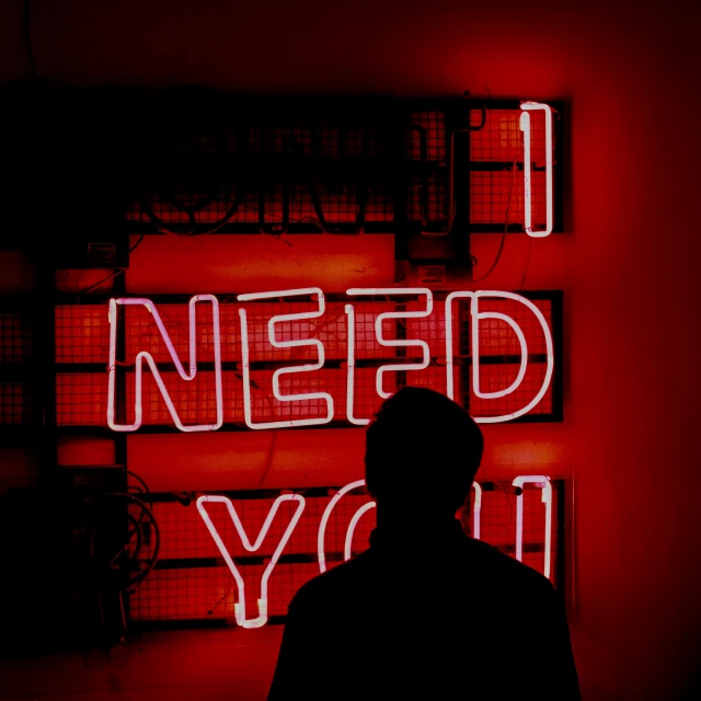 the man is standing in front of a neon display