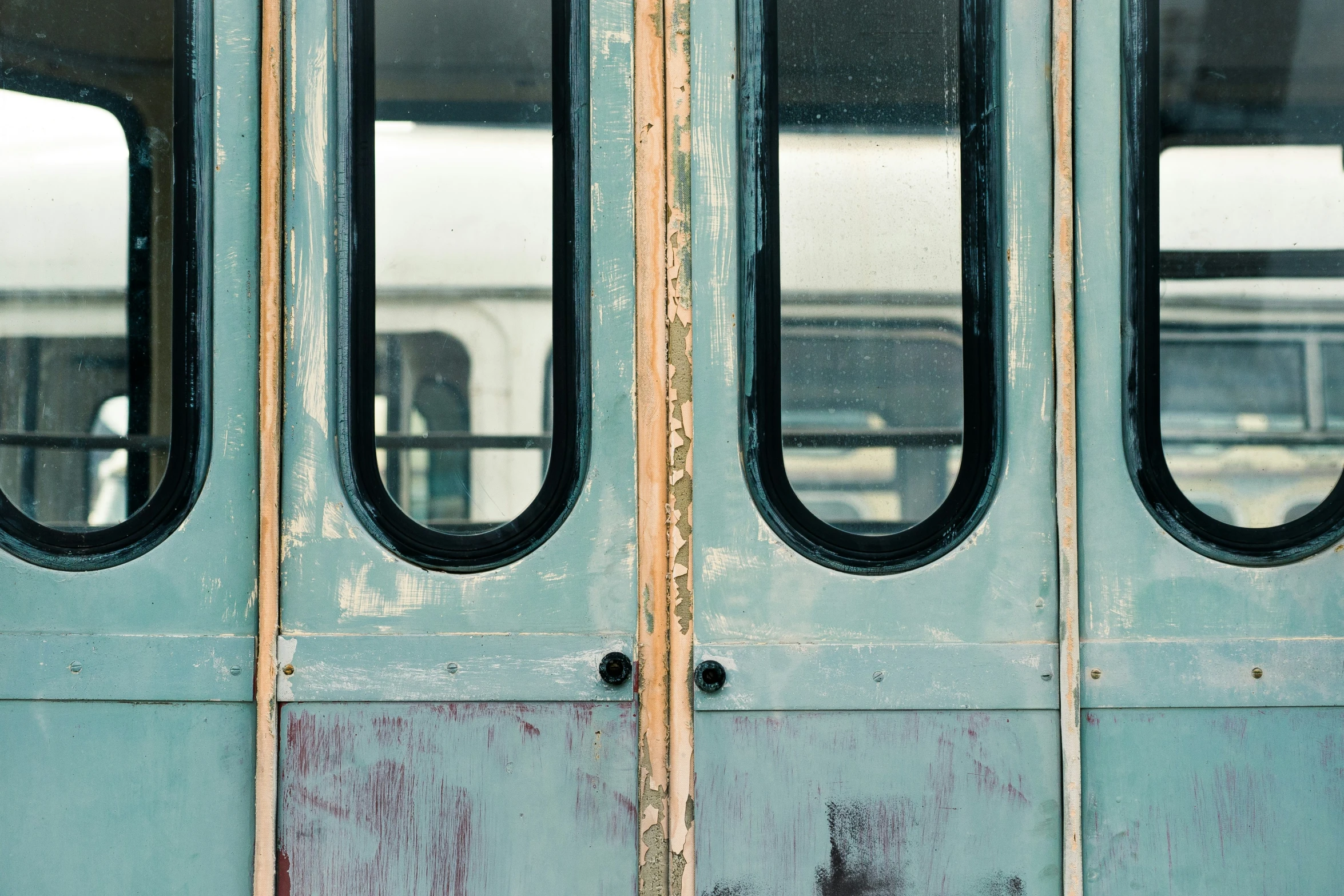 a blue door is opened with oval windows