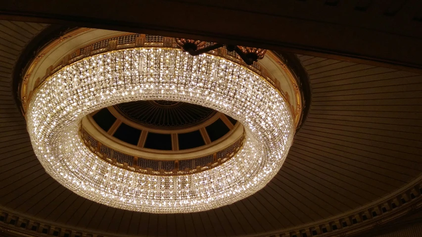 a round chandelier above a building ceiling