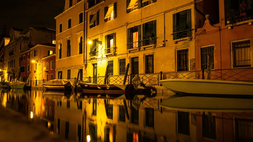 two boats floating down a canal in front of buildings