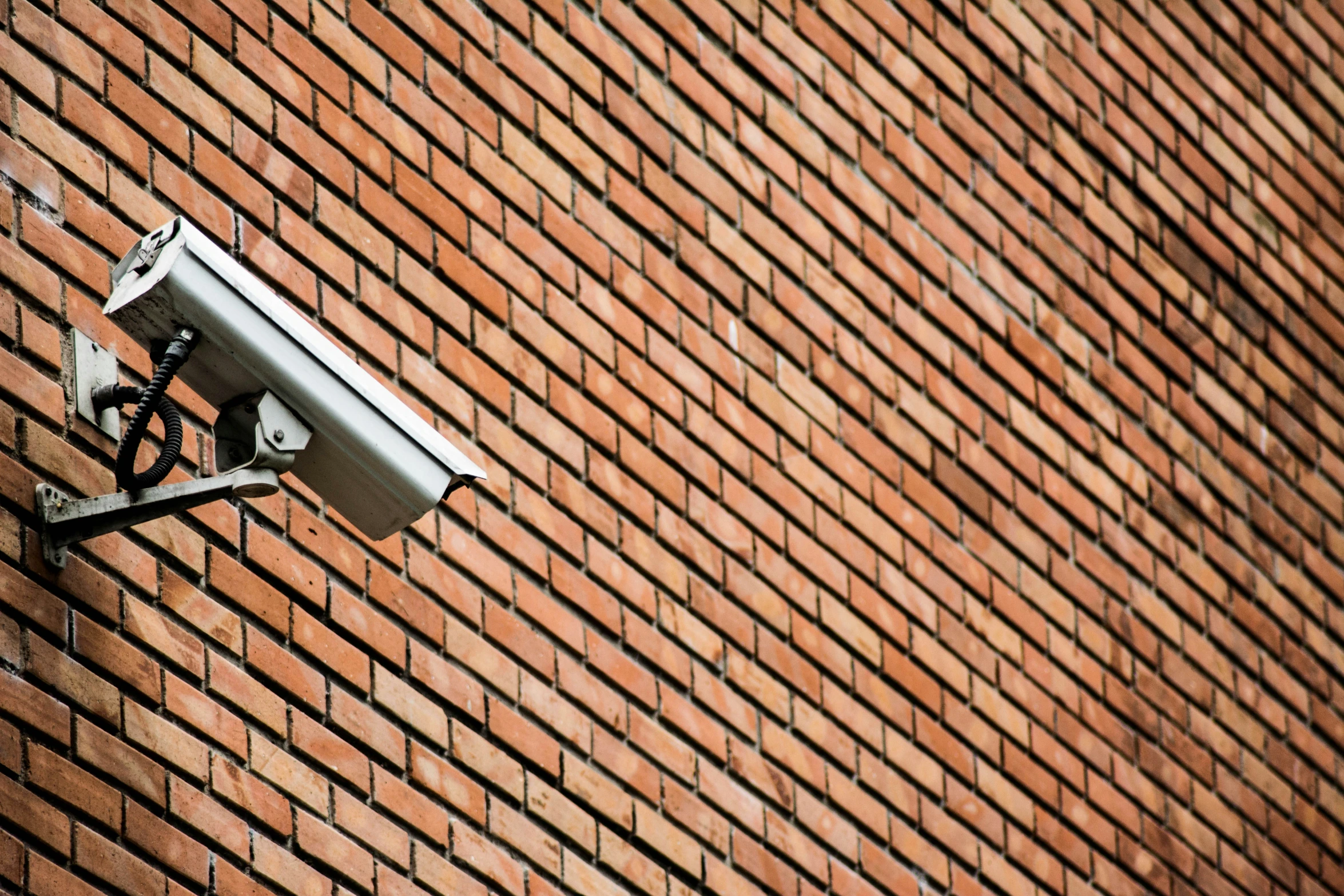 the security camera is on top of a brick wall