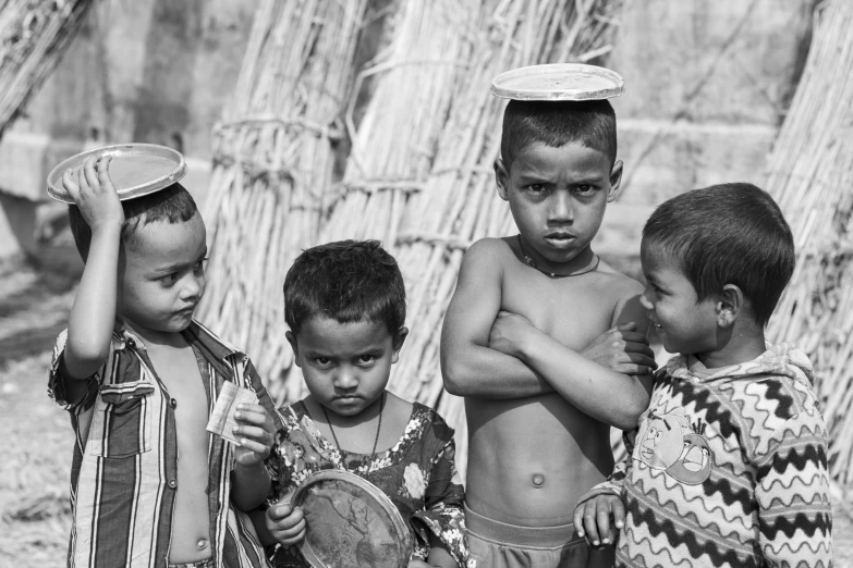 four boys in a village holding their drums