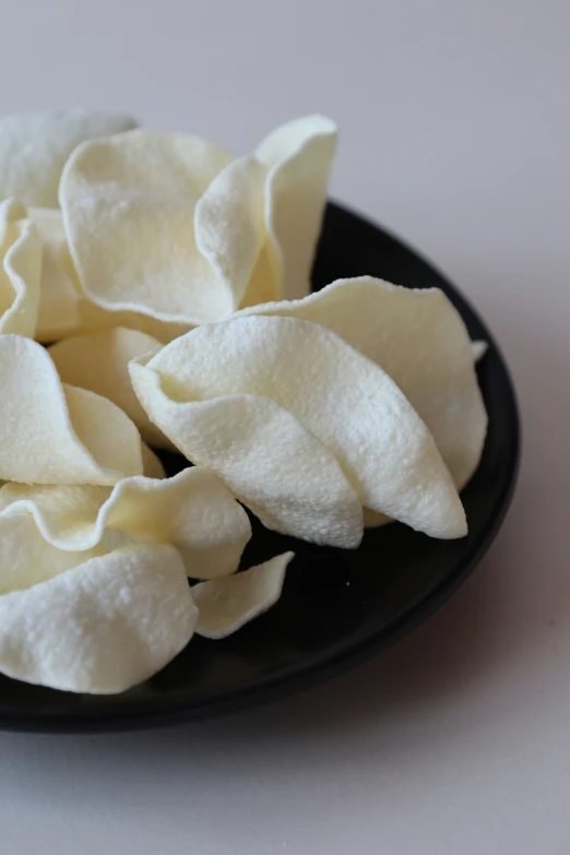 some chips are sitting in a black plate