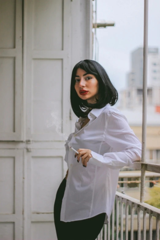 a woman in a shirt is posing on a balcony