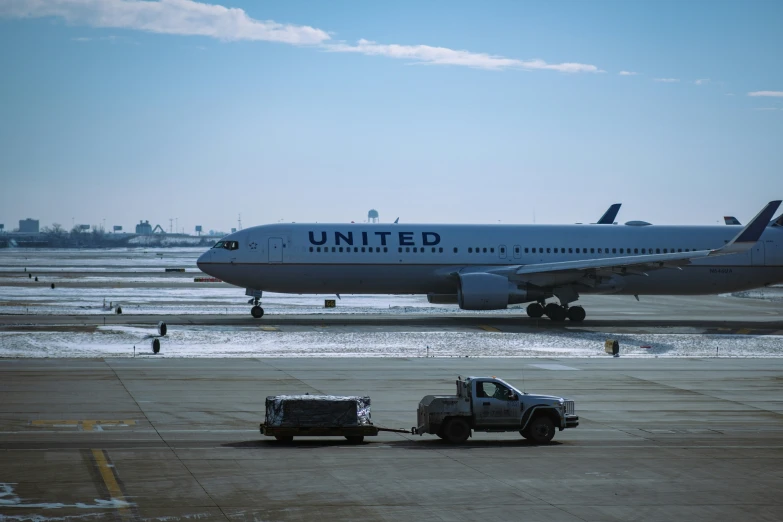 an airplane on the runway with trucks near it