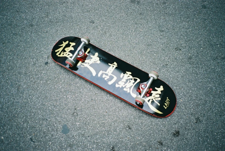 a skateboard with a picture of some asian characters on it