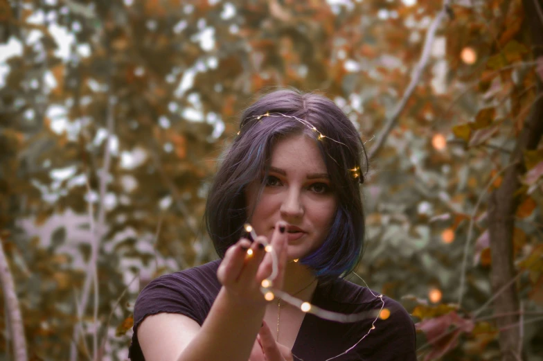 a woman holding a string of beads near her face