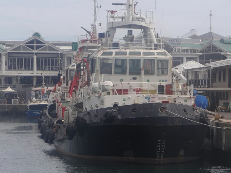 the boat is docked at the pier next to the building