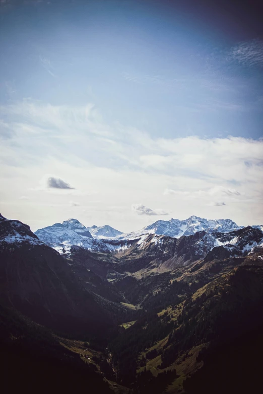 the snowy mountains are surrounded by green and blue trees