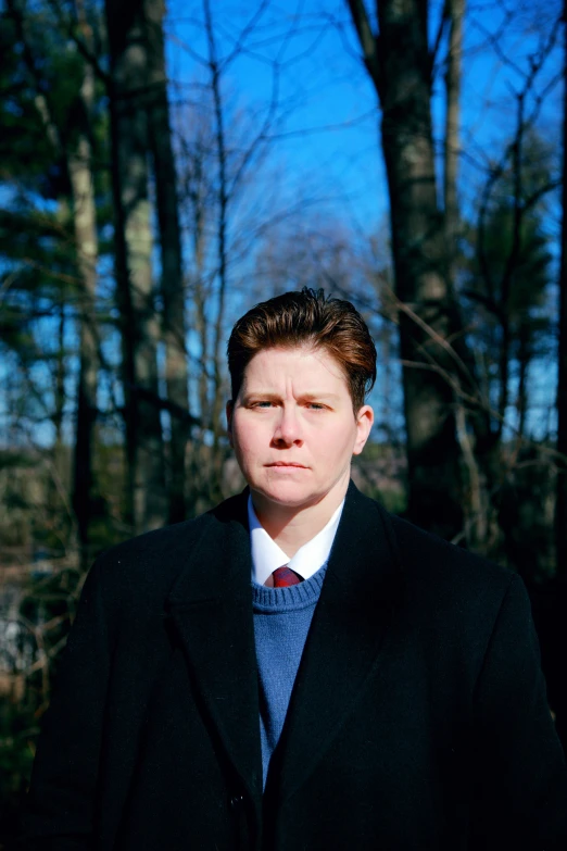 a man is standing in front of some trees