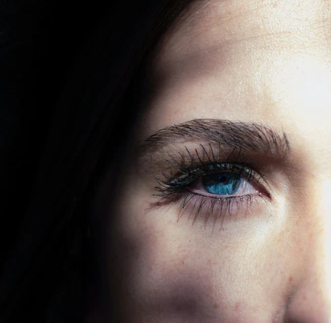 a woman's eye with long eyelashes and blue eyes