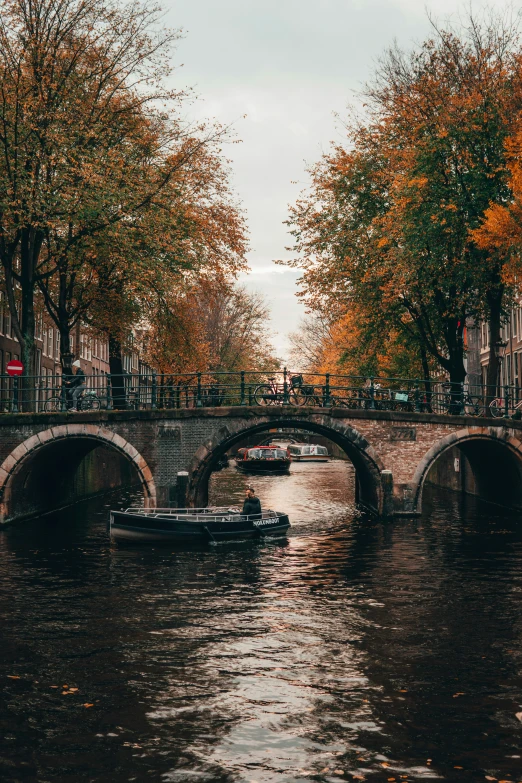 a boat moving down the river under an overpass