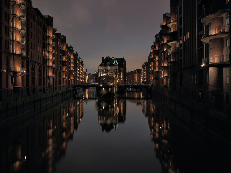 a river runs along a city street lined with buildings