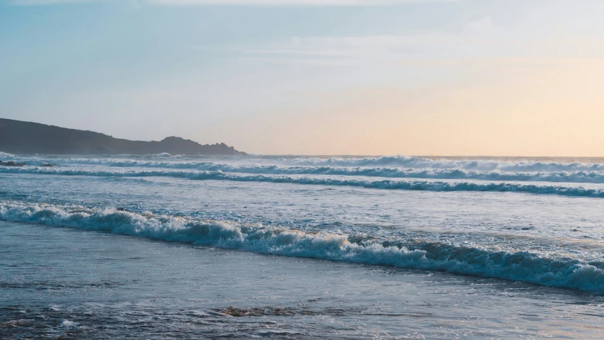 the person is carrying their surfboard out into the ocean