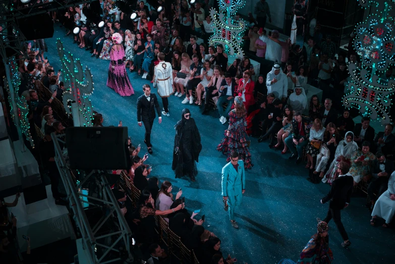 a bunch of people in costumes walk down the runway