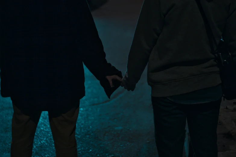 two people standing in the street holding hands