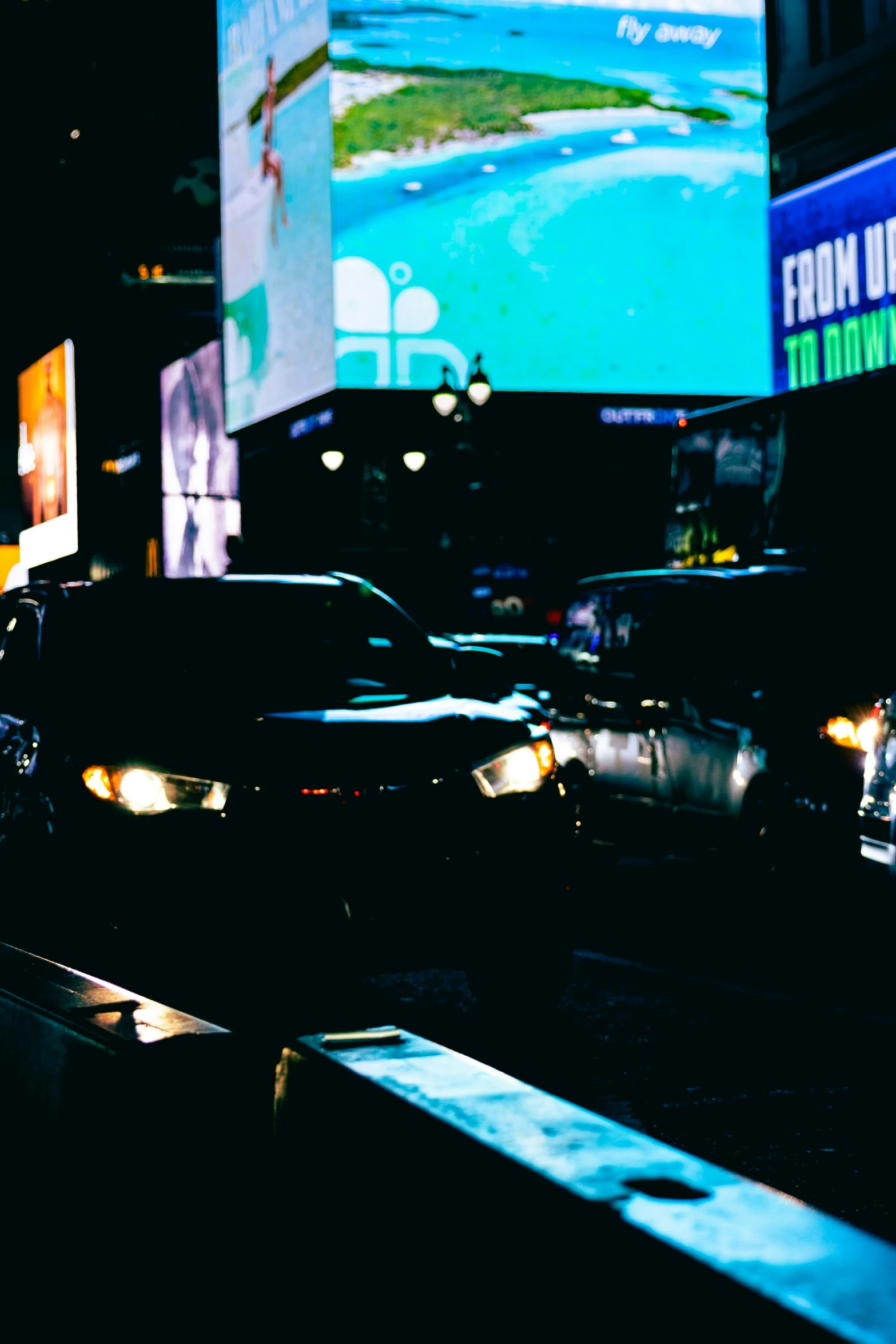 some cars parked near a road under lights