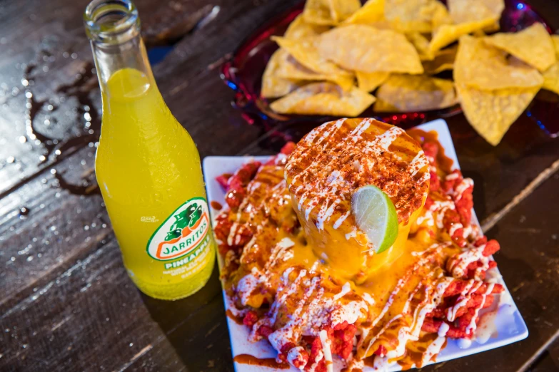 there are nachos and beer next to the plate of chips