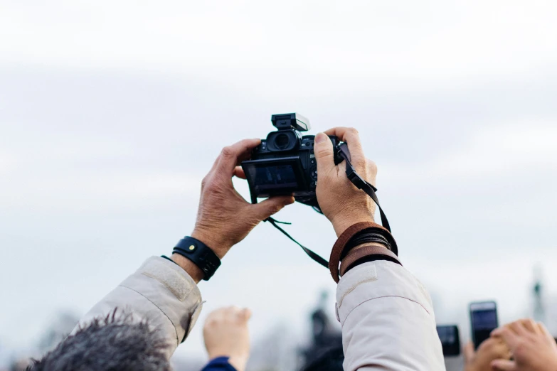 someone takes a picture with their digital camera while other people take pictures