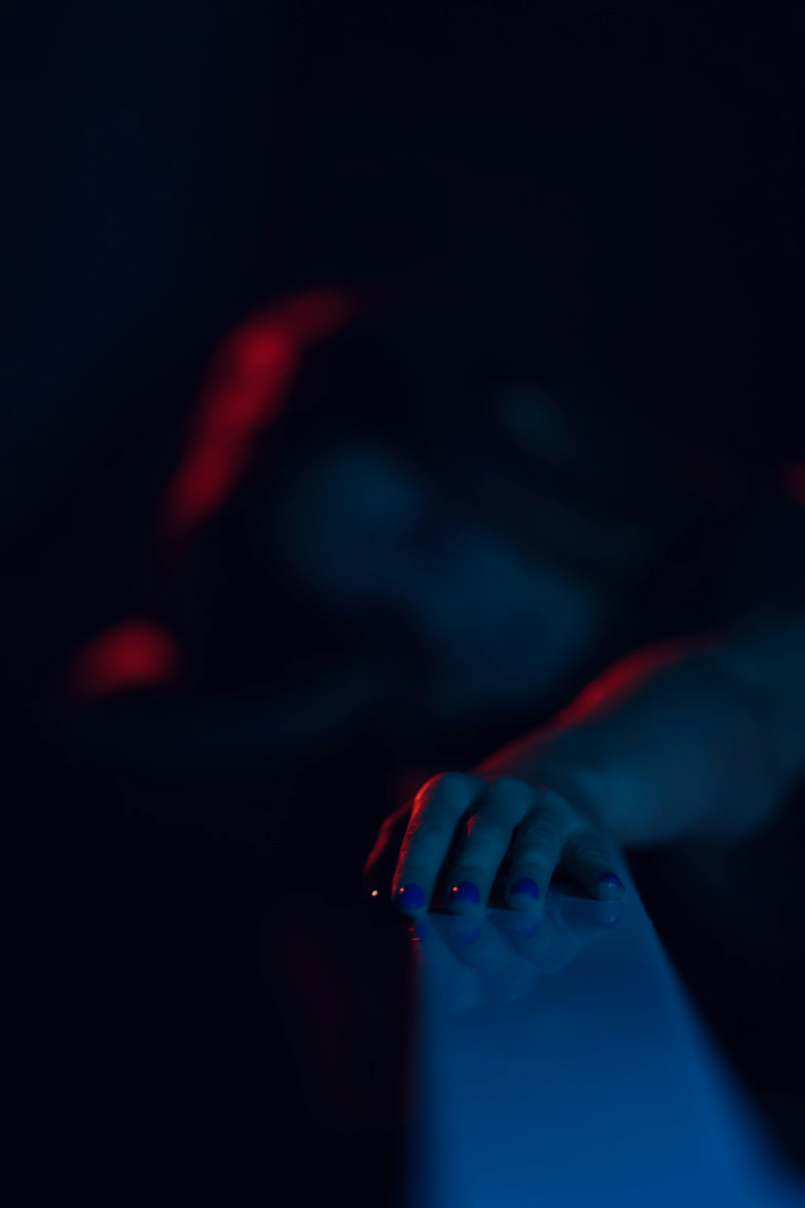 a hand touching the keyboard of a laptop in a dark room