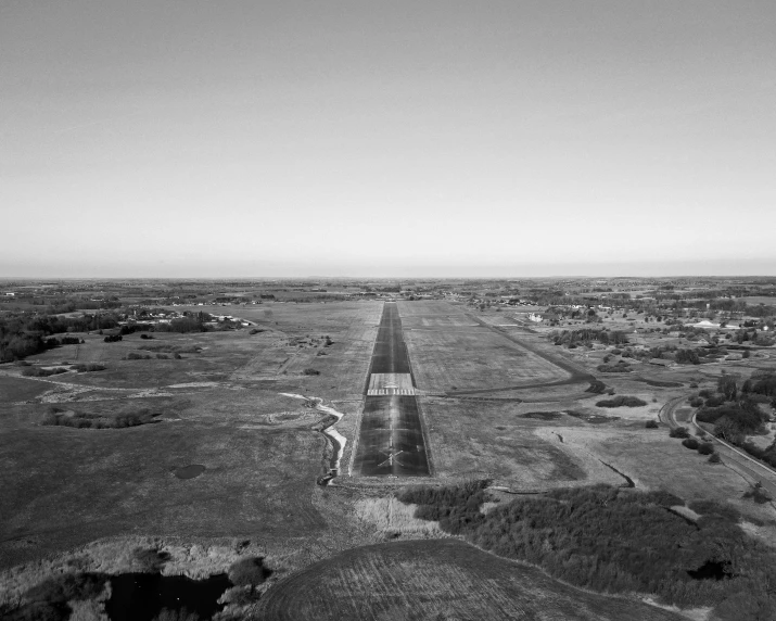 a large plane flying over a green field