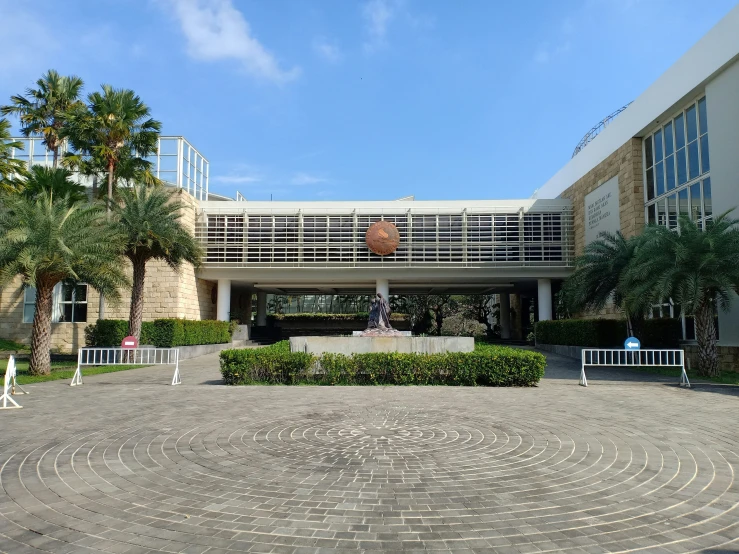 this is the entrance of a building with a circular walkway between it and a clock on it