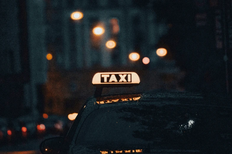night view of traffic with lights and taxi sign