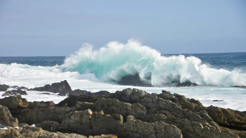 waves crashing on rocks in front of ocean