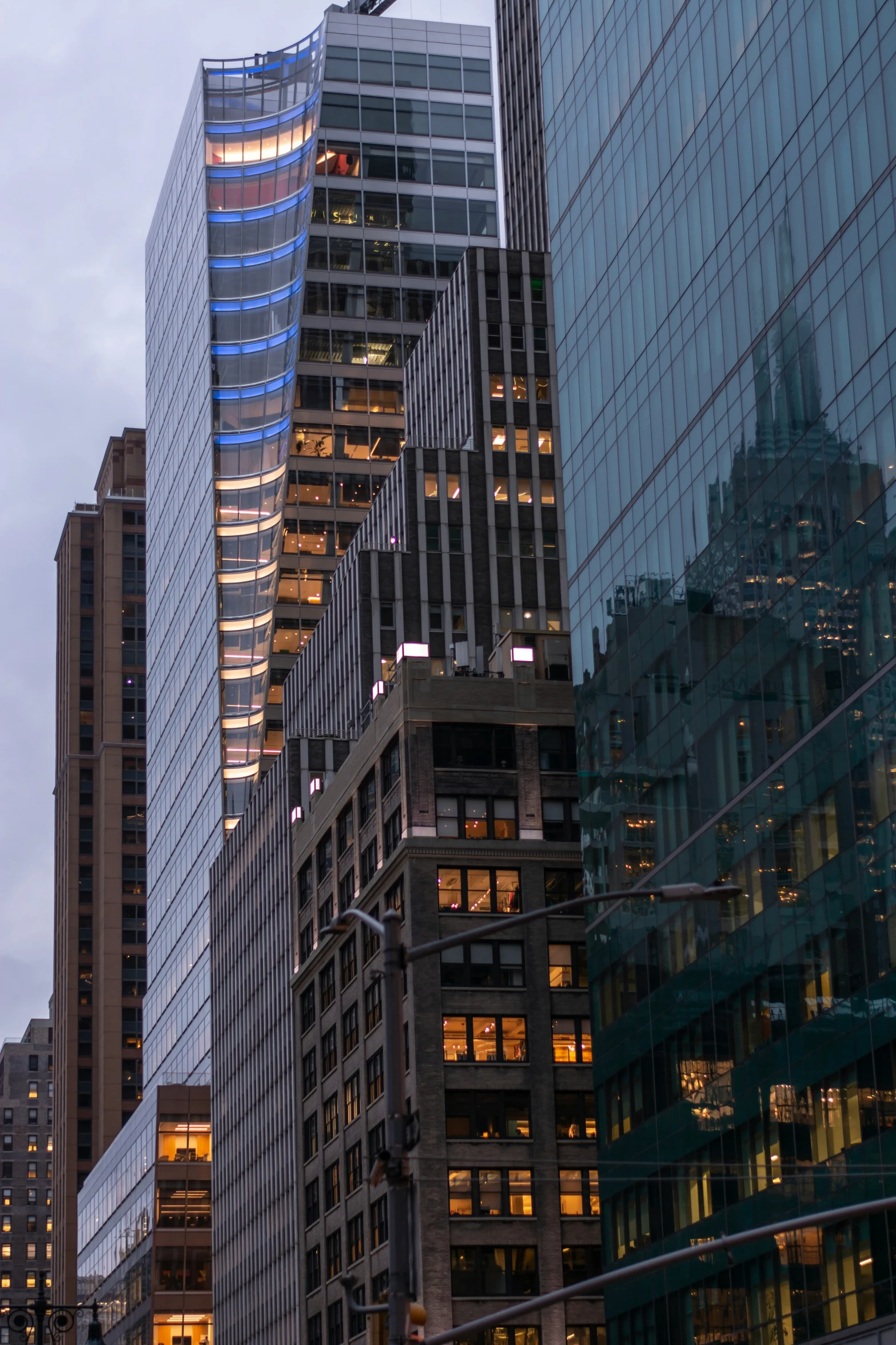 many buildings with glass and gold details, some lit up at night