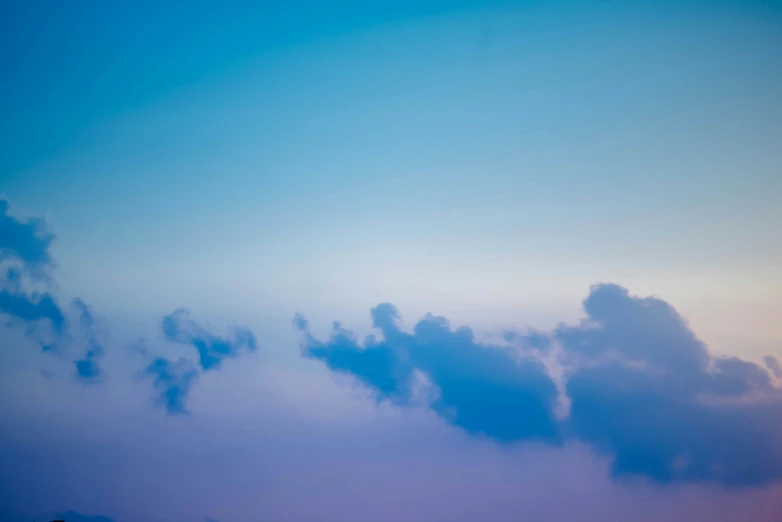 an airplane flying through a cloudy blue sky