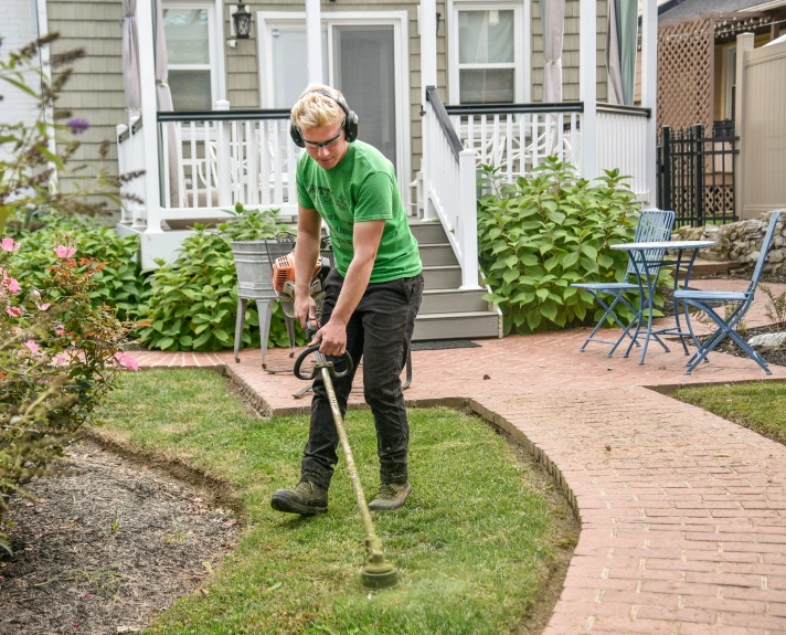 a woman in green shirt using a pressure washer