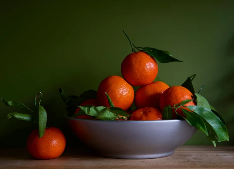 the fruit is in the white bowl on the table