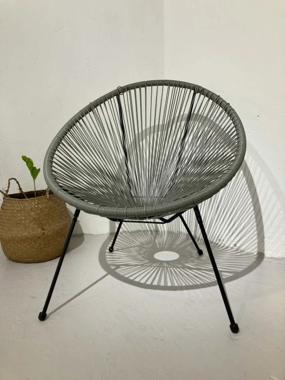 a round white wicker table next to a basket