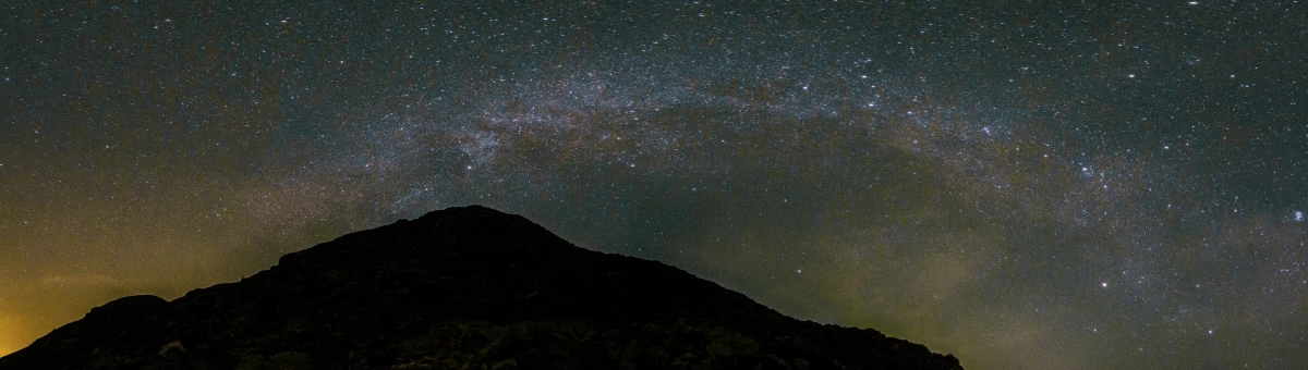 an image of a mountain range with the stars in the sky above