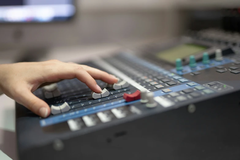 a person presses ons on an audio mixing console