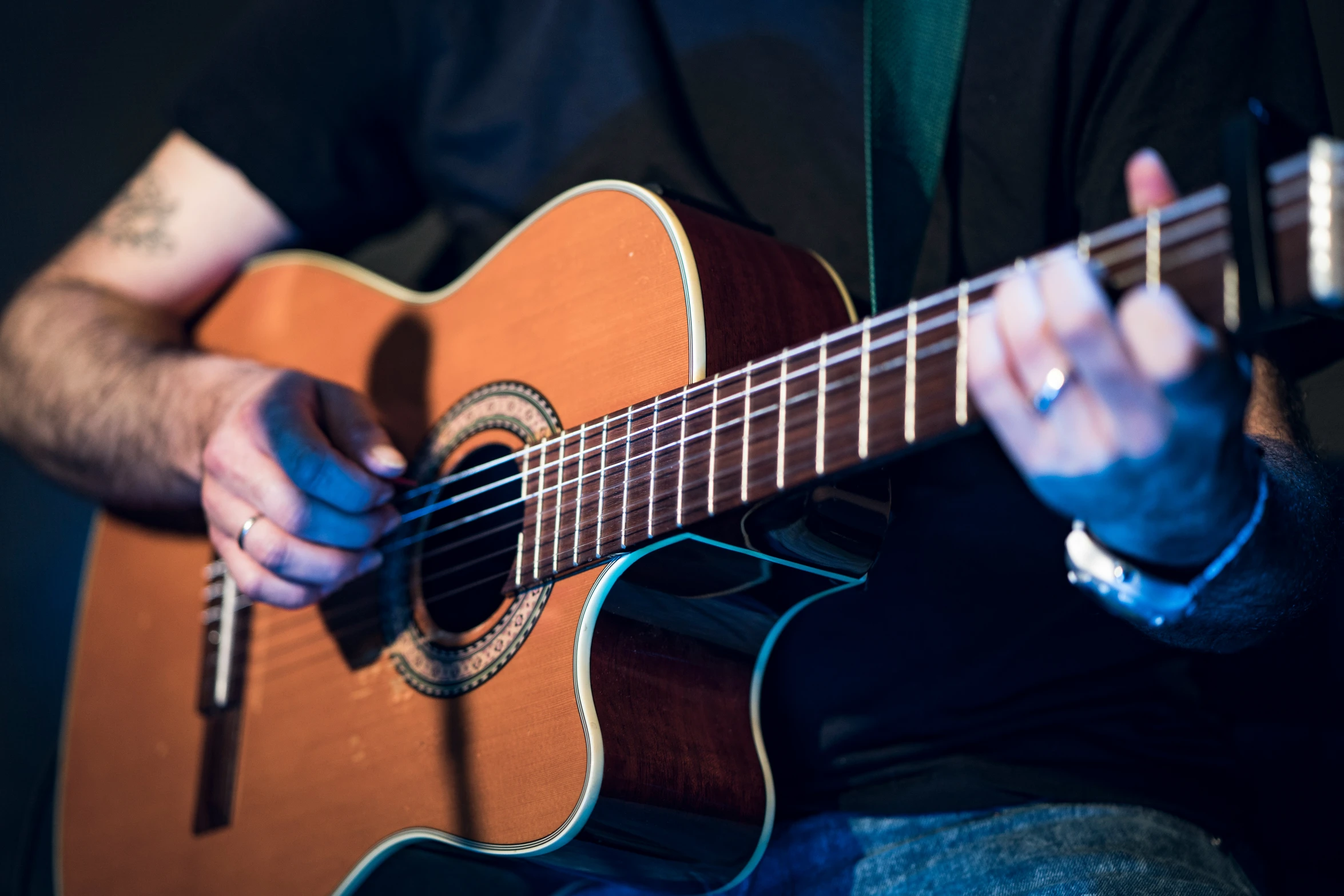 man in suit playing guitar and performing on stage