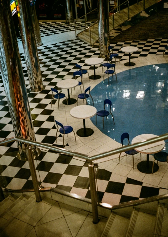 a swimming pool with chairs and tables in it