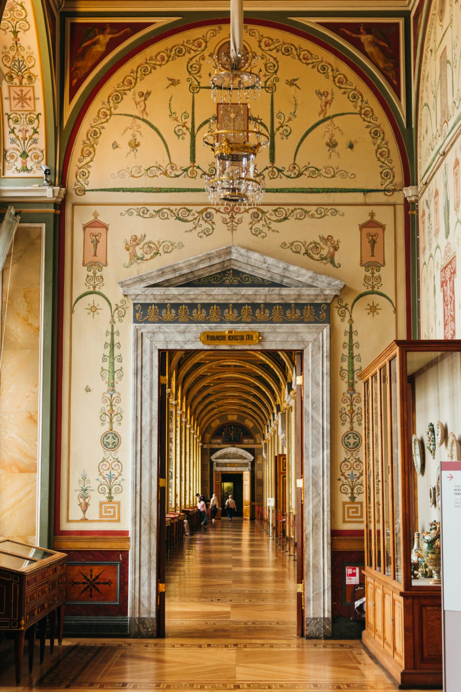 long hallway with chandelier and ceiling decorations in large building