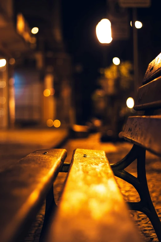 a park bench at night with some lights on the side