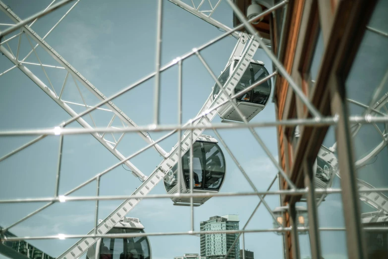 a very large ferris wheel seen through a metal fence