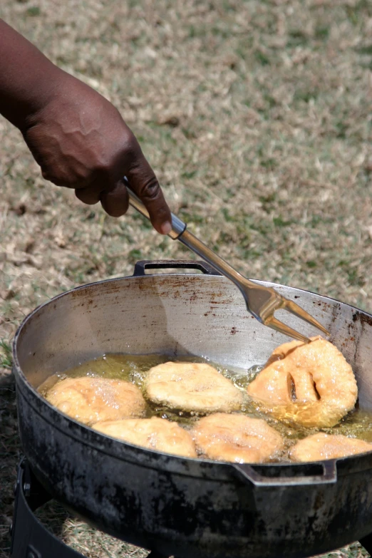 a person is grilling doughnuts on an open flame