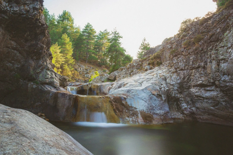 a view from inside of a cave looking down at a small waterfall