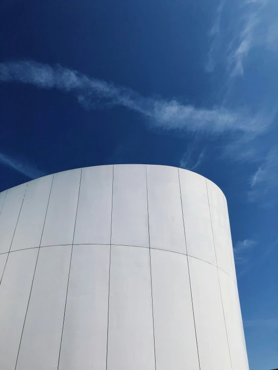 a big white round building under a blue sky