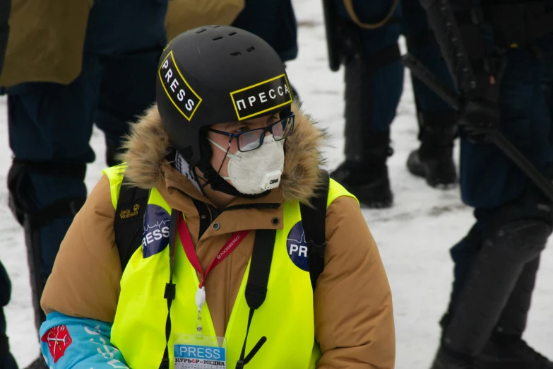 a person in a yellow coat wearing a mask and jacket