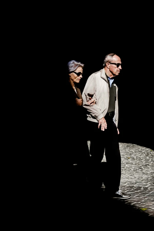 two older men walking away from the camera in the dark